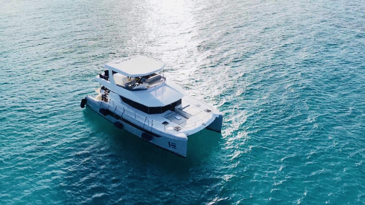 Drone view of the yacht cruising over clear blue water