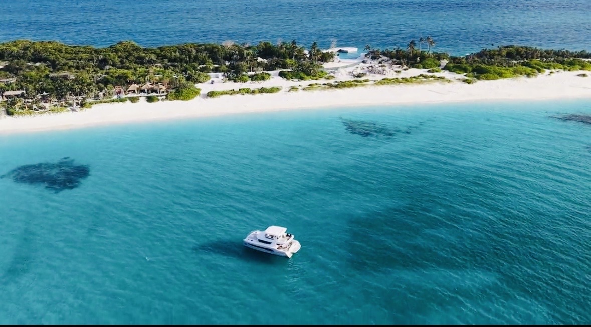 Catamaran floating in calm turquoise water by the beach