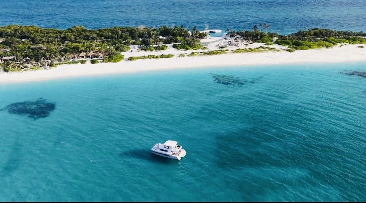 Catamaran floating in calm turquoise water by the beach