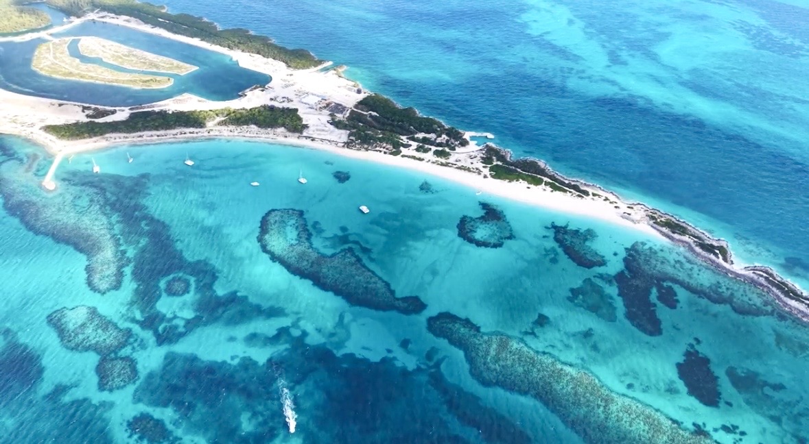 Aerial view of a white sand cay and shallow blue water