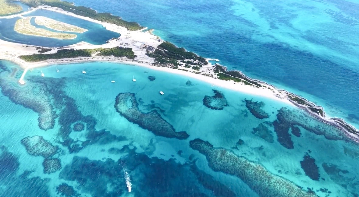 Aerial view of a white sand cay and shallow blue water